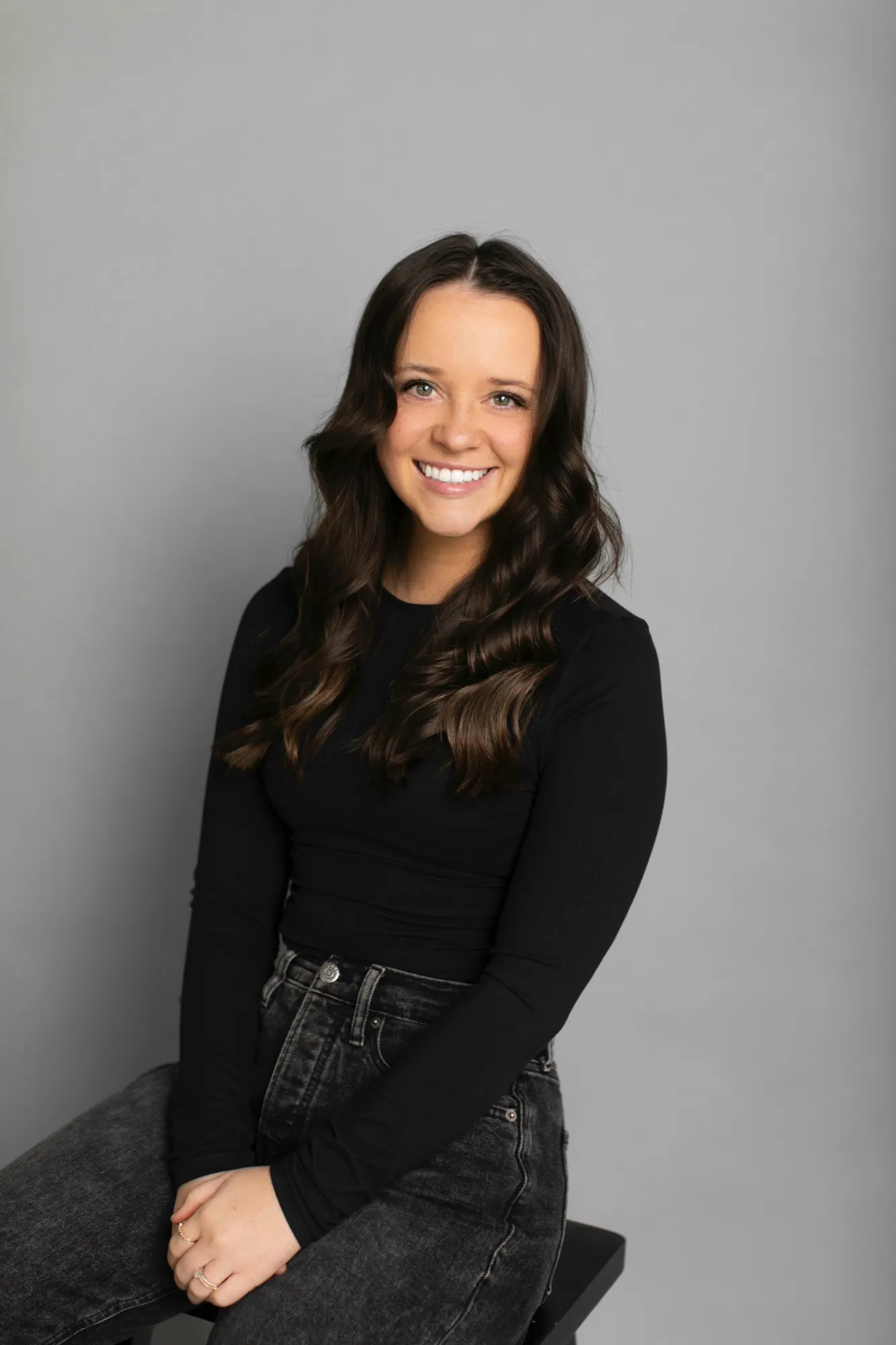 Kaylee Jensen smiling, seated, wearing a black top